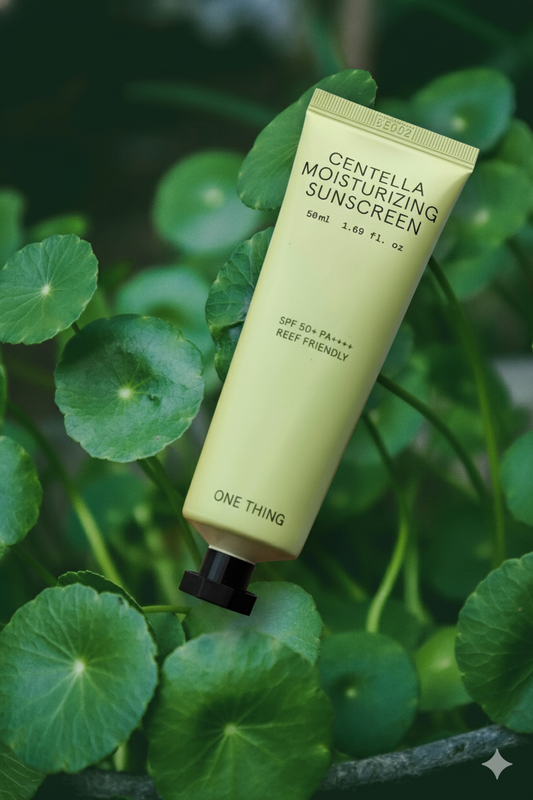 Centella Moisturizing Sunscreen tube angled amongst lush green centella asiatica leaves.